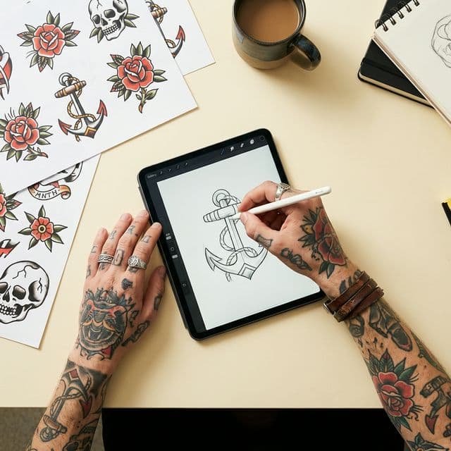 Tattoo artist consulting with a client over reference designs